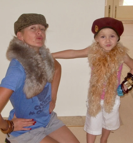 Two people wearing fur collars and hats indoors